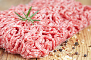 closeup of ground beef in a roughly patty shape with a garnish